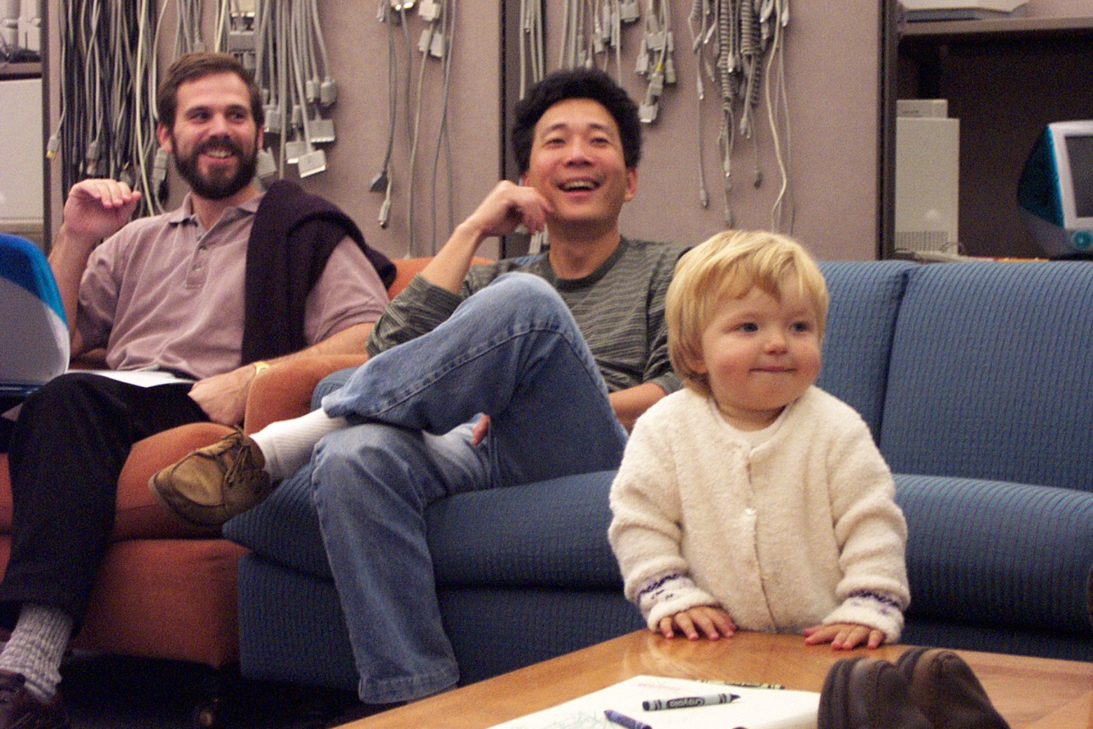A colleague, my boss, and my older daughter (with crayons) at an Apple meeting around 2000
