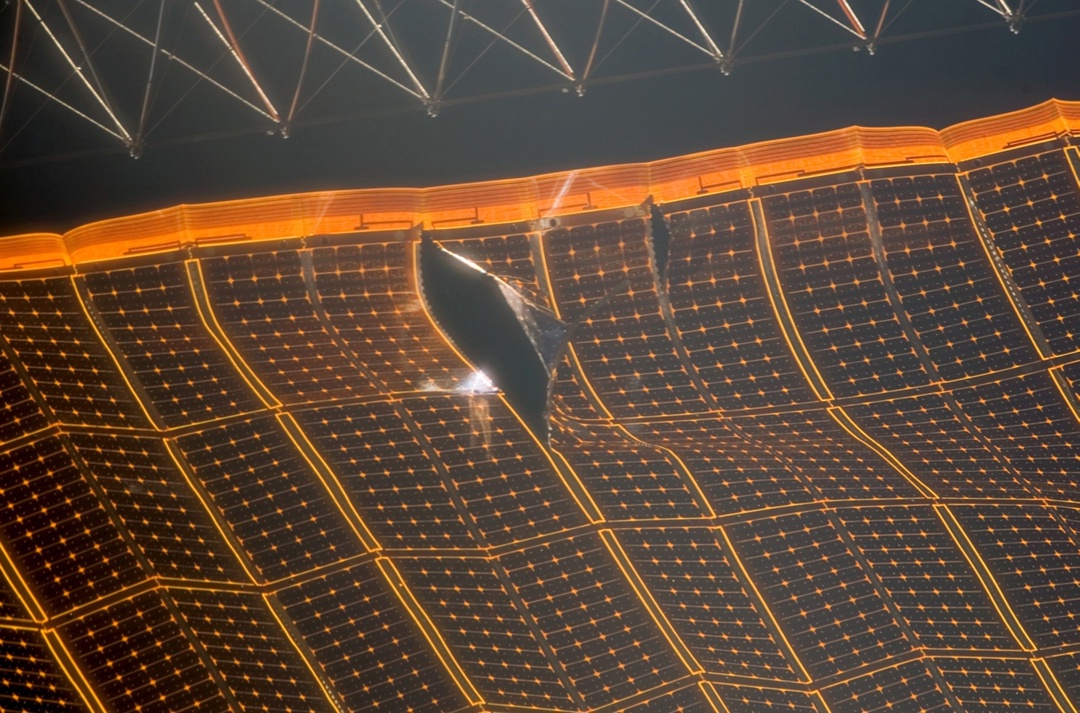 Your panel's got a hole! In the photo — a damaged solar array wing on the ISS