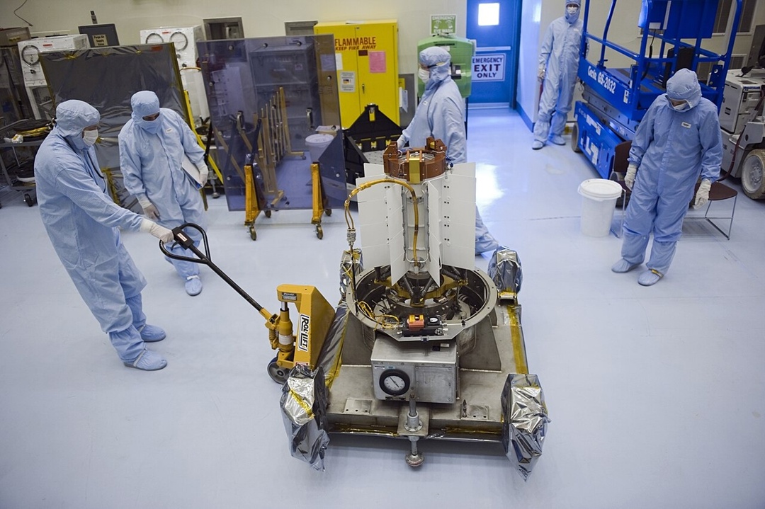 NASA staff wheeling a brand-new RTG for Curiosity through the Kennedy Space Center on a cart